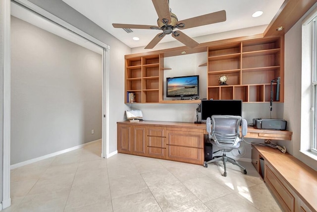 office space with ceiling fan, light tile patterned flooring, and built in desk