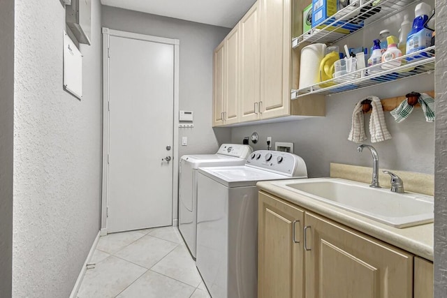 clothes washing area featuring cabinets, independent washer and dryer, light tile patterned floors, and sink