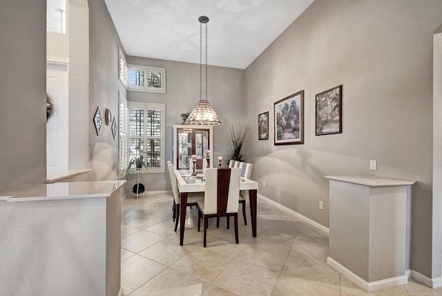 dining room featuring light tile patterned floors and a towering ceiling