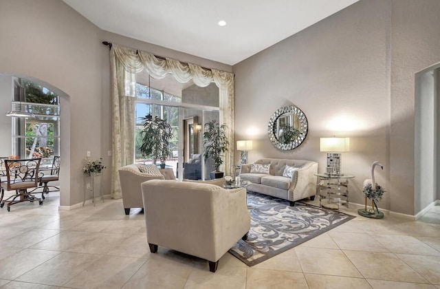 tiled living room with a towering ceiling