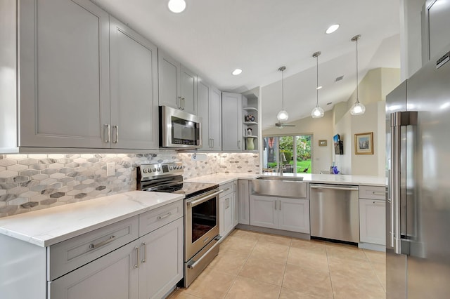 kitchen featuring light stone countertops, gray cabinets, stainless steel appliances, open shelves, and a sink