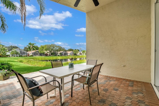 view of patio / terrace featuring ceiling fan and a water view