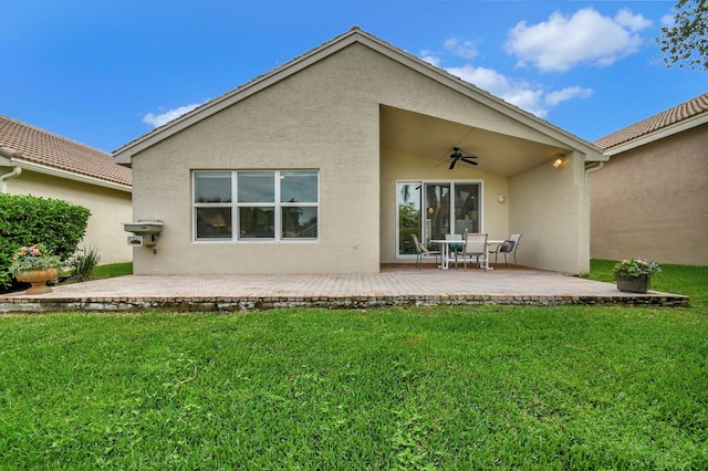 rear view of property featuring a lawn, ceiling fan, and a patio area