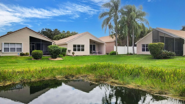 back of property featuring a sunroom and a yard