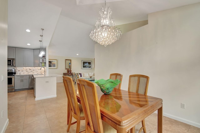 tiled dining area featuring vaulted ceiling, sink, and an inviting chandelier