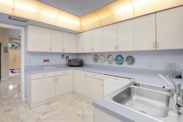 kitchen featuring tasteful backsplash, white cabinets, sink, and white dishwasher