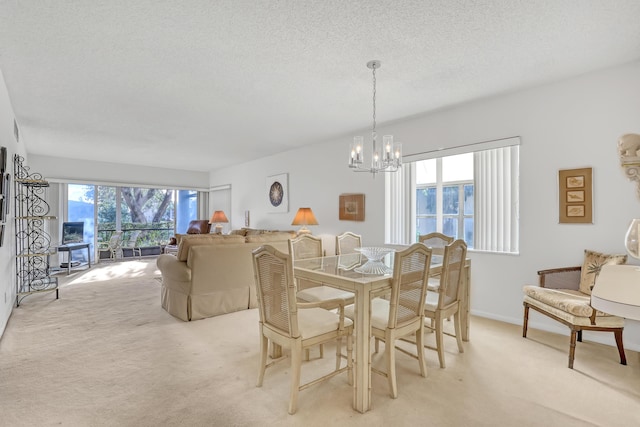 dining room featuring a textured ceiling, light colored carpet, and an inviting chandelier