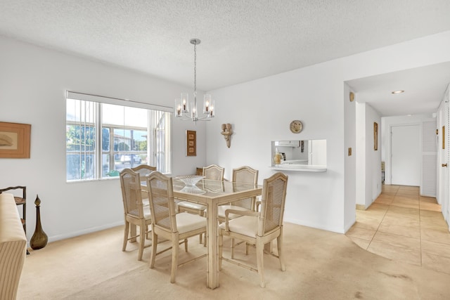 dining room featuring a textured ceiling, a notable chandelier, and light carpet