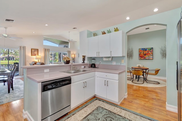 kitchen featuring kitchen peninsula, a wealth of natural light, dishwasher, and vaulted ceiling