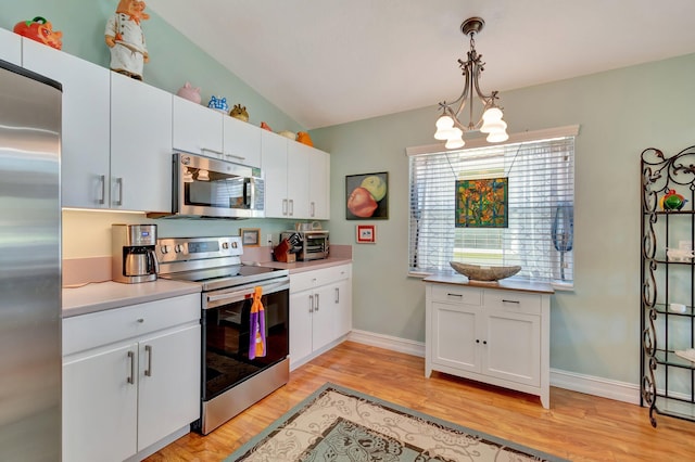 kitchen with white cabinetry, pendant lighting, light wood-type flooring, and appliances with stainless steel finishes