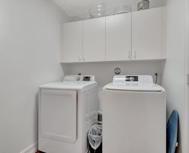 laundry area featuring washer and dryer and cabinets