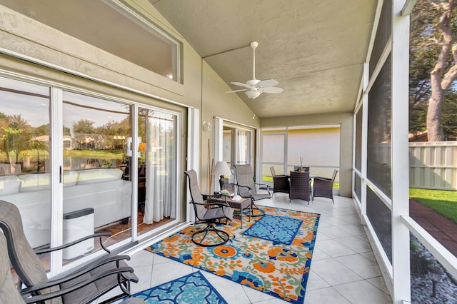 sunroom with vaulted ceiling, a wealth of natural light, and ceiling fan