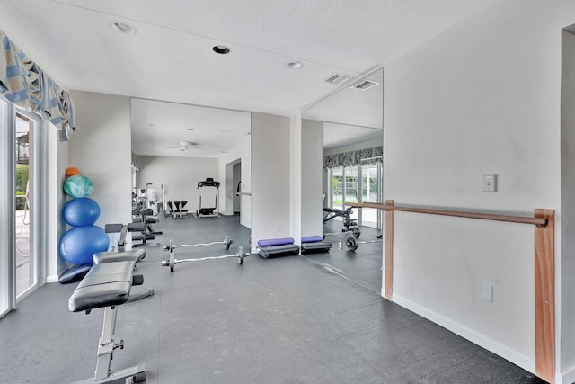 workout area with ceiling fan and a textured ceiling