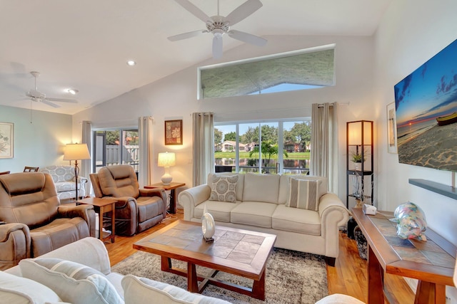 living room featuring light hardwood / wood-style floors, plenty of natural light, lofted ceiling, and ceiling fan