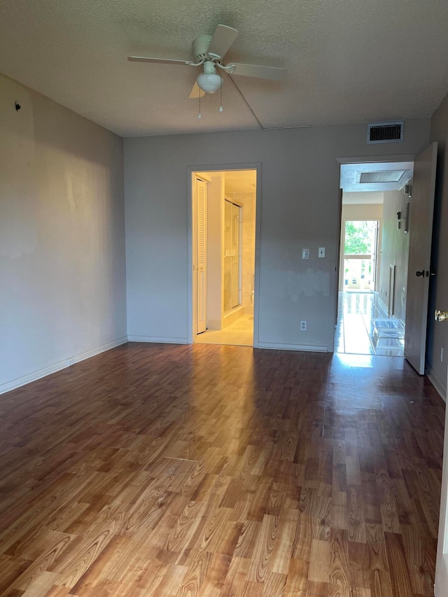 empty room featuring a textured ceiling, light hardwood / wood-style floors, and ceiling fan