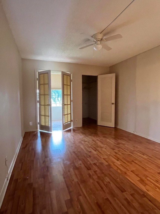 empty room featuring hardwood / wood-style floors, ceiling fan, and french doors