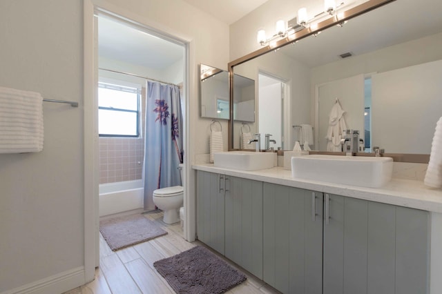 full bathroom with shower / bath combo, vanity, and toilet