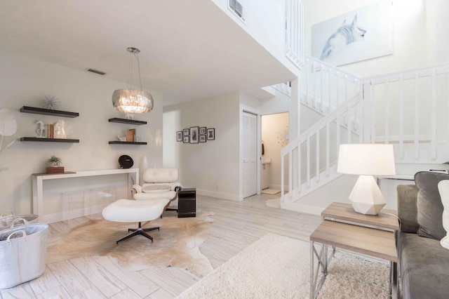 living room featuring light hardwood / wood-style flooring and a notable chandelier