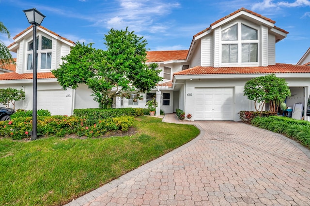 view of front of home with a garage and a front lawn