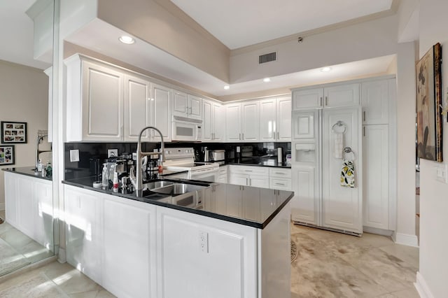 kitchen with white appliances, white cabinets, decorative backsplash, ornamental molding, and kitchen peninsula