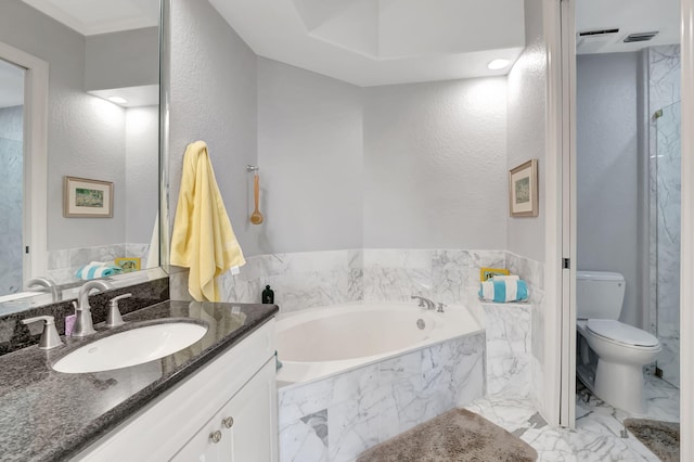 bathroom with vanity, a relaxing tiled tub, and toilet