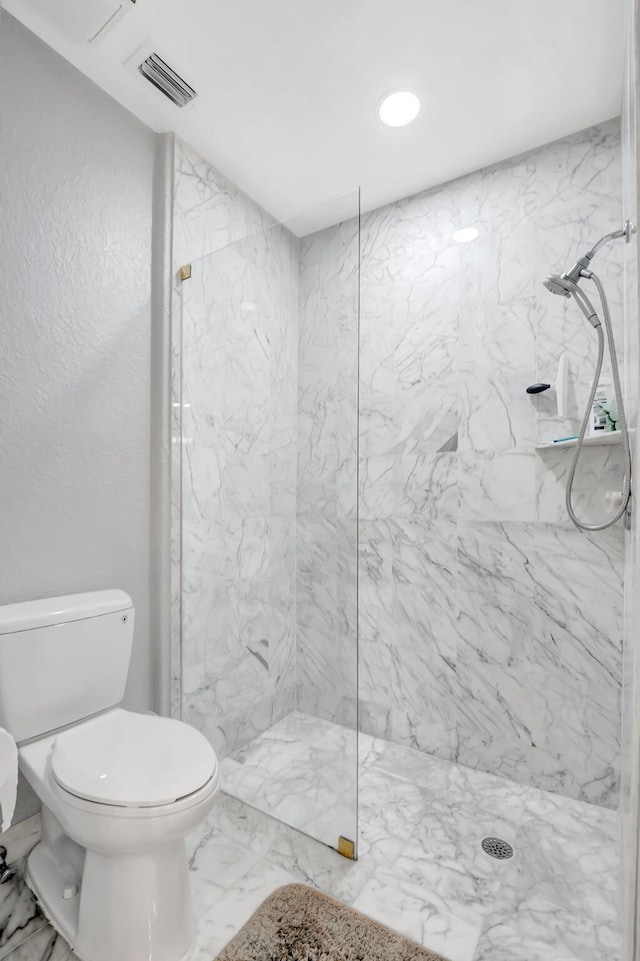 bathroom featuring toilet and tiled shower