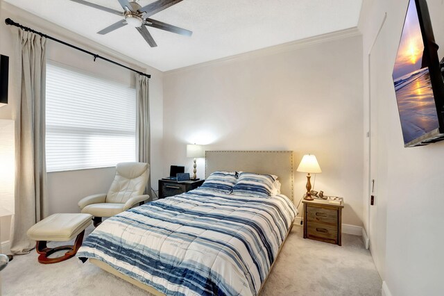 bedroom with ceiling fan, light carpet, and ornamental molding