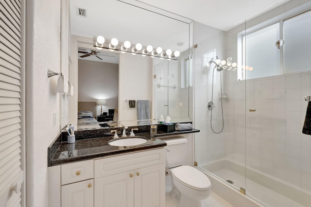 bathroom featuring vanity, toilet, an enclosed shower, and ceiling fan