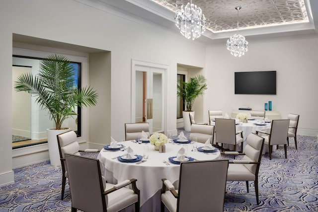 carpeted dining room with a tray ceiling and an inviting chandelier