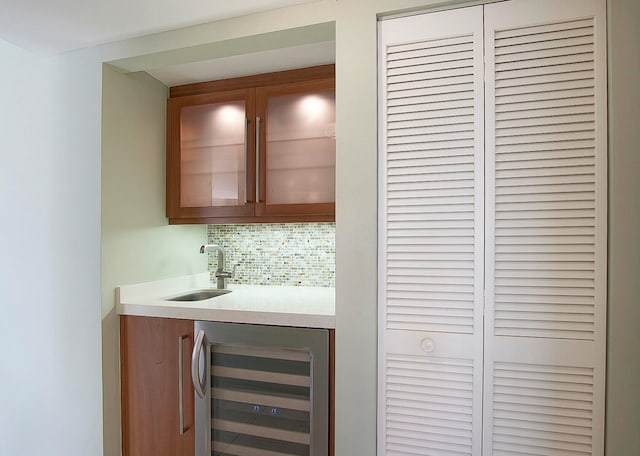 bar with backsplash, beverage cooler, and sink