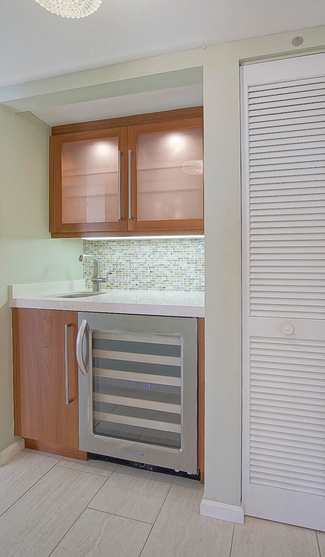 bar featuring light tile patterned flooring, tasteful backsplash, wine cooler, and sink