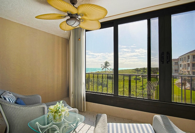 sunroom / solarium featuring a water view, a wealth of natural light, and ceiling fan