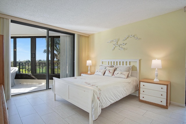 bedroom with expansive windows, access to outside, french doors, and a textured ceiling