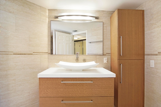 bathroom with vanity, tile walls, and decorative backsplash