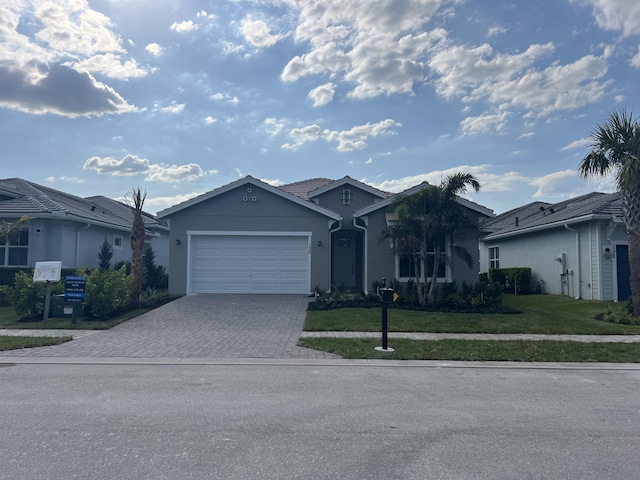 ranch-style home featuring stucco siding, an attached garage, driveway, and a front lawn