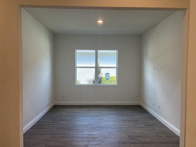 empty room featuring recessed lighting, baseboards, and dark wood-style flooring