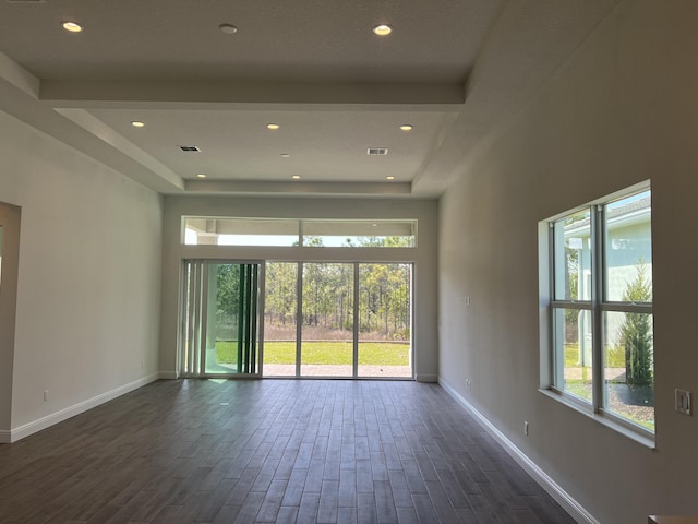 spare room with a wealth of natural light, baseboards, dark wood finished floors, and recessed lighting