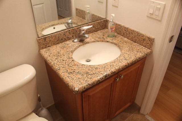 bathroom featuring tile patterned flooring, vanity, and toilet