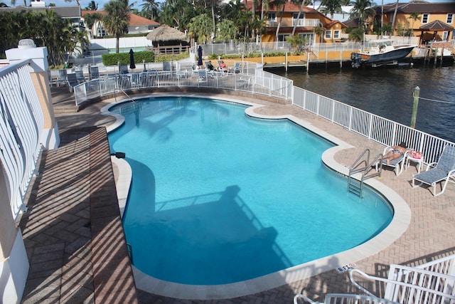 view of pool with a water view and a patio area