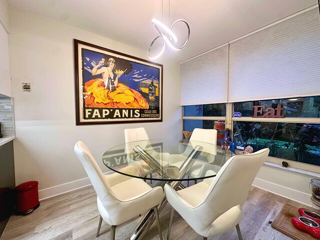 interior details with backsplash, stainless steel refrigerator, and light hardwood / wood-style flooring