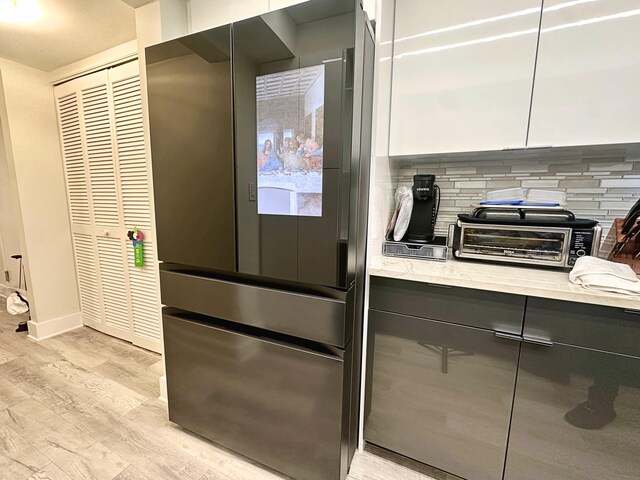 laundry area with separate washer and dryer and light hardwood / wood-style flooring