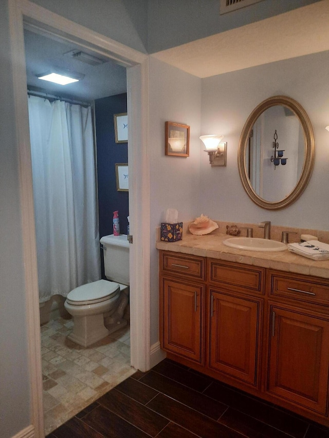 bathroom featuring walk in shower, vanity, and toilet