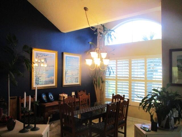 dining space featuring vaulted ceiling and a notable chandelier