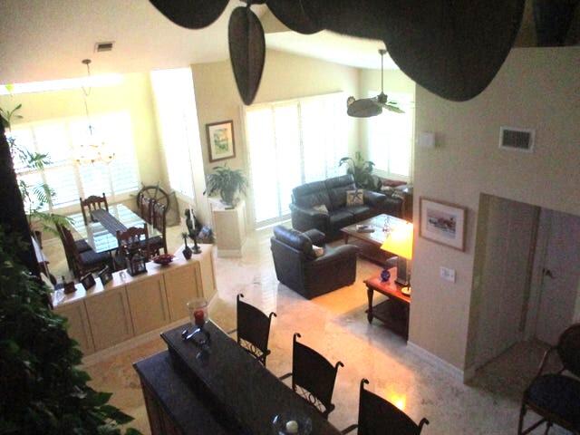 living room with a high ceiling and ceiling fan