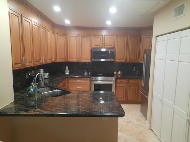 kitchen featuring decorative backsplash, kitchen peninsula, sink, and appliances with stainless steel finishes