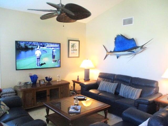 living room featuring ceiling fan and vaulted ceiling