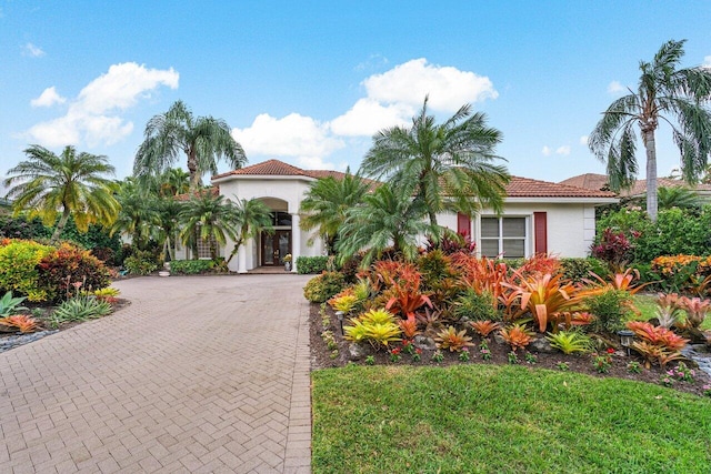 mediterranean / spanish-style home with a front lawn