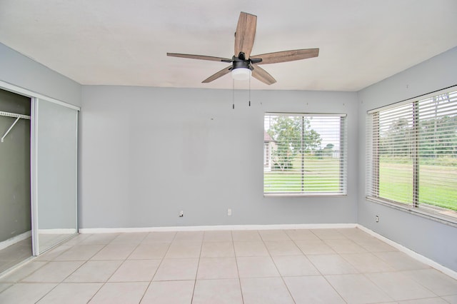 unfurnished bedroom featuring ceiling fan, a closet, and light tile patterned flooring