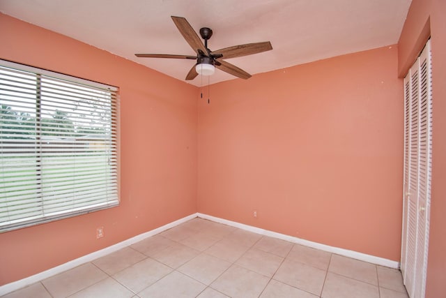 tiled empty room featuring ceiling fan