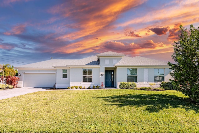 view of front of home with a garage and a lawn